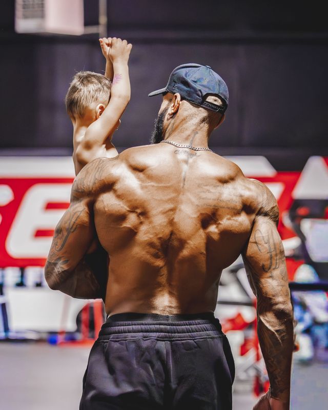 Coach Jae in the gym with his son on his shoulders